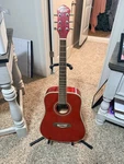 Oscar Schmidt By Washburn Red 6-STRING Right-handed Acoustic Guitar With Stand. Fixed Price $130.00.